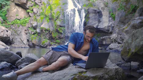 Working-On-Laptop-At-The-Waterfall-In-The-Forest.